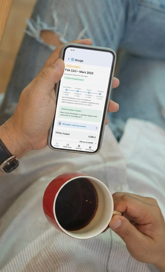 Un café et un téléphone sur un bureau chez Dougs