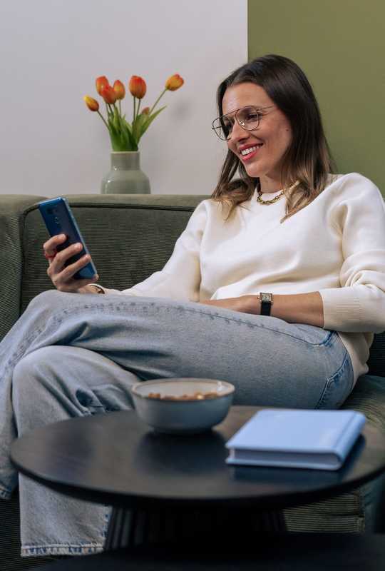Une entrepreneuse qui consulte son appli Dougs chez elle